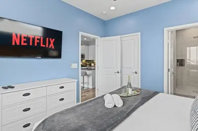 a bedroom with a bed with a netflix sign on the wall at Saratoga Sunset - Rooftop - Sleek - Walk to Beach in San Diego