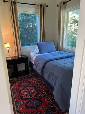 a bedroom with a bed and a window and a rug at laguna beach cottage home in Laguna Beach
