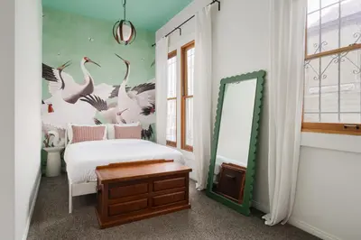 a bedroom with a bed and a mirror at Victorian Retreat in Barrio Logan 1mi to Downtown in San Diego