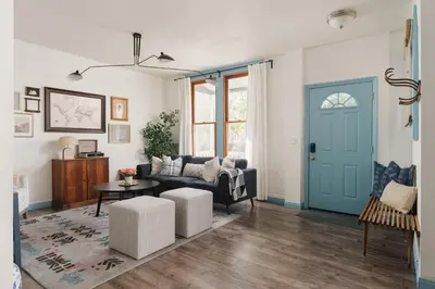 a living room with a blue door and a couch at Victorian Retreat in Barrio Logan 1mi to Downtown in San Diego