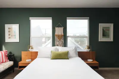 a bedroom with a white bed and two windows at Victorian Retreat in Barrio Logan 1mi to Downtown in San Diego