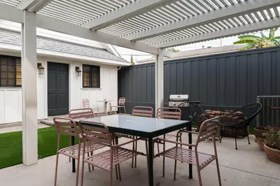 a patio with a table and chairs under a pergola at Victorian Retreat in Barrio Logan 1mi to Downtown in San Diego