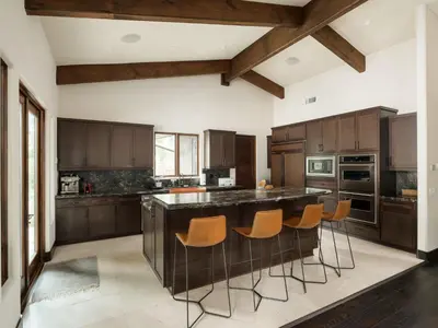 a kitchen with wooden cabinets and a large island with bar stools at Private Resort in Lake Hodges in Escondido