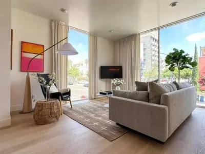 a living room with a couch and a large window at Rooftop with Views Modern Little Italy Townhome in San Diego