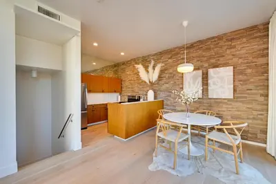 a dining room and kitchen with a brick wall at Rooftop with Views Modern Little Italy Townhome in San Diego