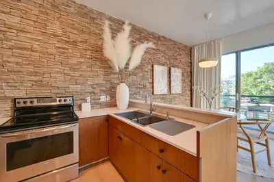 a kitchen with a brick wall and a stove top oven at Rooftop with Views Modern Little Italy Townhome in San Diego