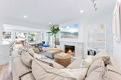 a living room with a couch and a fireplace at Magical Bayfront Home w Epic Dock on Peninsula in Newport Beach