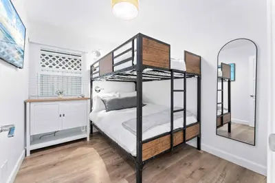 a bedroom with two bunk beds and a mirror at Magical Bayfront Home w Epic Dock on Peninsula in Newport Beach