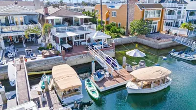 an aerial view of a house with boats in the water at Magical Bayfront Home w Epic Dock on Peninsula in Newport Beach
