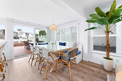 a dining room with a table and chairs at Magical Bayfront Home w Epic Dock on Peninsula in Newport Beach