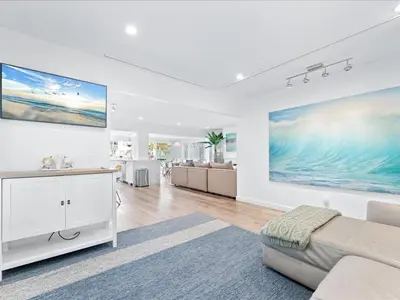 a living room with a couch and a large painting on the wall at Stunning Bayfront Home w Epic Dock on Peninsula in Newport Beach