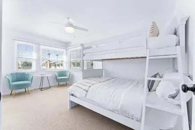 a white bedroom with a bunk bed and a desk at Stunning Bayfront Home w Epic Dock on Peninsula in Newport Beach