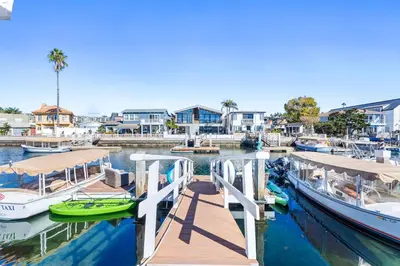 two boats docked at a dock in a marina at Stunning Bayfront Home w Epic Dock on Peninsula in Newport Beach
