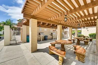 a wooden pergola with benches and tables on a patio at San Diego Condo Pool Access, 8 Mi to Downtown in San Diego