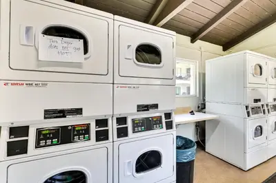 a laundry room with white washer and dryer machines at San Diego Condo Pool Access, 8 Mi to Downtown in San Diego