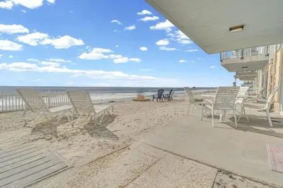 a group of chairs and tables on the beach at Seaview 1135A in Oceanside