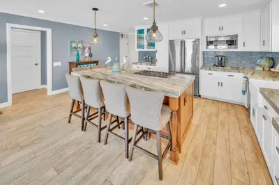 a kitchen with a large island with bar chairs at Seaview 1135A in Oceanside