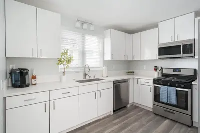 a white kitchen with white cabinets and appliances at Bankers Hill Chic Roomy Home Near Airport in San Diego