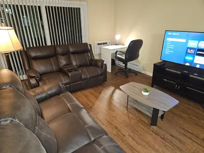 a living room with a leather couch and a flat screen tv at Luxurious stay near the beach in Newport Beach