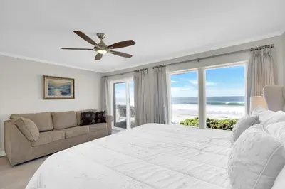 a bedroom with a large white bed and a couch at Seaview 1133A in Oceanside