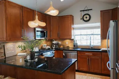 a kitchen with wooden cabinets and a black counter top at Stylish PB Townhome, Walk to Bay, and Balcony in San Diego
