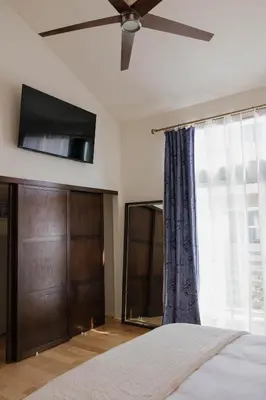 a bedroom with a bed with a ceiling fan and a window at Stylish PB Townhome, Walk to Bay, and Balcony in San Diego