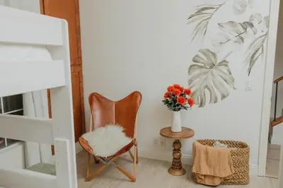 a room with a chair and a vase of flowers at Stylish PB Townhome, Walk to Bay, and Balcony in San Diego