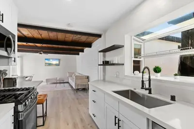 a kitchen with white cabinets and a sink at Cozy, bright, and walk to Crown Point Park/Bay in San Diego