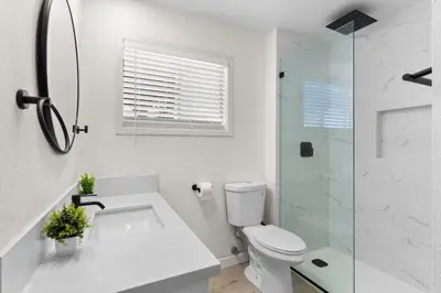 a white bathroom with a toilet and a shower at Cozy, bright, and walk to Crown Point Park/Bay in San Diego