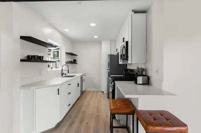 a kitchen with white cabinets and a sink and a stove at Cozy, bright, and walk to Crown Point Park/Bay in San Diego