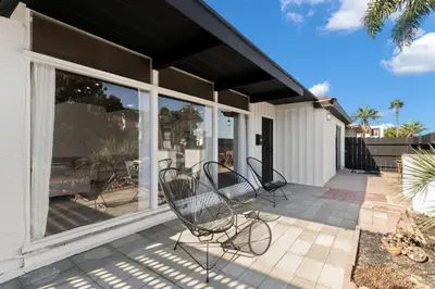 a patio with two chairs and windows on a house at Cozy, bright, and walk to Crown Point Park/Bay in San Diego