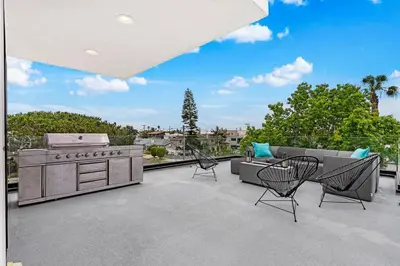 a patio with a stove and chairs on a roof at Bright Designer Oasis - Block from Bay - Roof Deck in San Diego