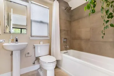 a bathroom with a toilet and a tub and a sink at Bright Designer Oasis - Block from Bay - Roof Deck in San Diego