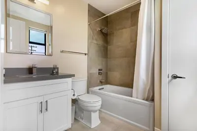 a bathroom with a tub and a toilet and a sink at Bright Designer Oasis - Block from Bay - Roof Deck in San Diego