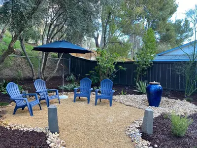 a group of blue chairs and an umbrella in a yard at Quiet Retreat With Pool And Hot Tub in Escondido