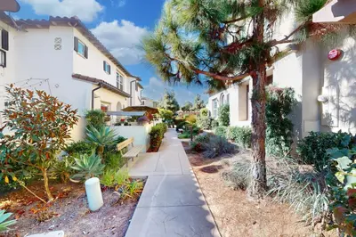 a walkway in front of a building with a tree at Leucadia Stonesteps Retreat in Encinitas