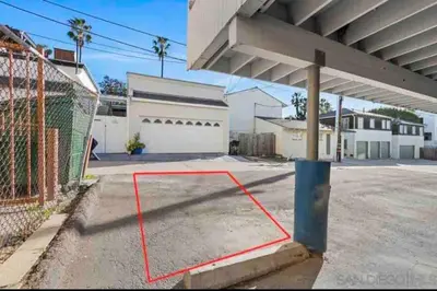 a parking lot with a red line in front of a building at La Jolla Townhouse steps away from Windansea beach in San Diego