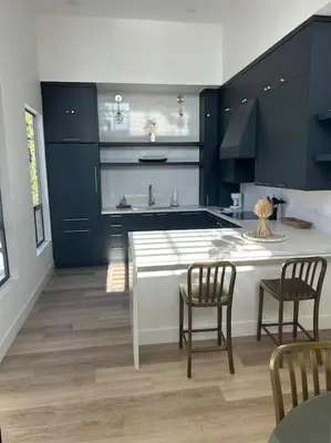 a kitchen with blue cabinets and a table and chairs at La Jolla Townhouse steps away from Windansea beach in San Diego