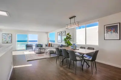 a dining room and living room with a table and chairs at Rip Tide in San Diego