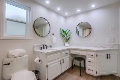 a bathroom with a sink and a toilet and mirrors at Rip Tide in San Diego