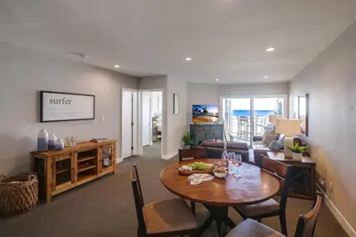 a living room with a table and chairs and a couch at Salt Life in San Diego