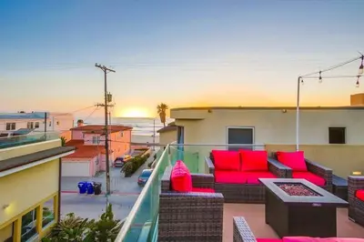 a balcony with red furniture and a view of the ocean at Sky High in San Diego