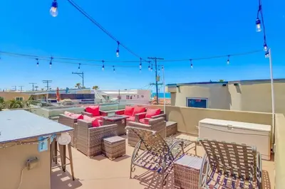 a patio with chairs and tables on a roof at Sky High in San Diego