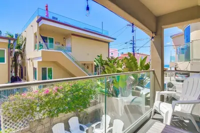 a balcony with white chairs and a building at Sky High in San Diego