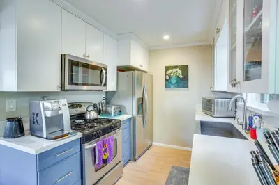 a kitchen with blue cabinets and a stove top oven at Costa Mesa Rental with Private Hot Tub and Fire Pit! in Costa Mesa