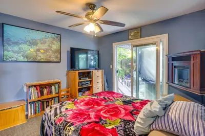 a bedroom with a bed with red flowers on it at Costa Mesa Rental with Private Hot Tub and Fire Pit! in Costa Mesa