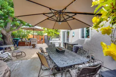 a table and chairs with an umbrella on a patio at Costa Mesa Rental with Private Hot Tub and Fire Pit! in Costa Mesa