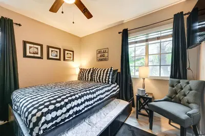 a bedroom with a bed and a chair and a window at San Diego Family Home with Lush Backyard Patio! in San Diego