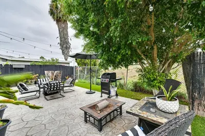a patio with a grill and chairs and a table at San Diego Family Home with Lush Backyard Patio! in San Diego