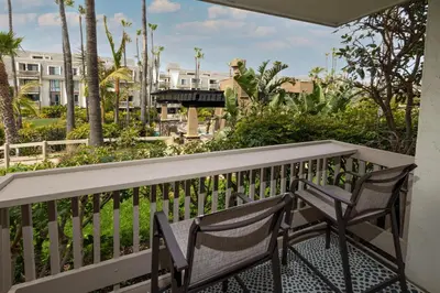a balcony with two chairs and a table at Oceanside Beach Condos in Oceanside